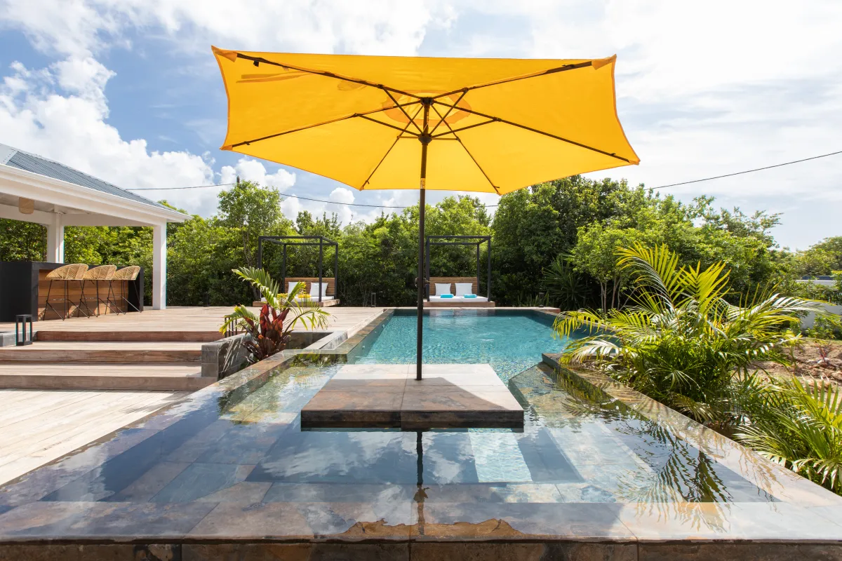 Villa Nuit D'Etoiles: Swimming pool with a yellow umbrella, wooden sun deck, bar, and outdoor daybeds