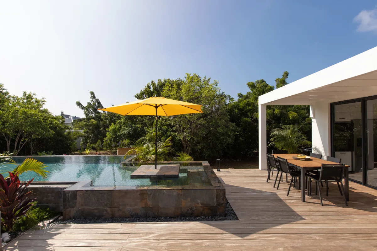 Villa Nuit D'Etoiles: Swimming pool with umbrella next to a wooden deck and covered outdoor dining area