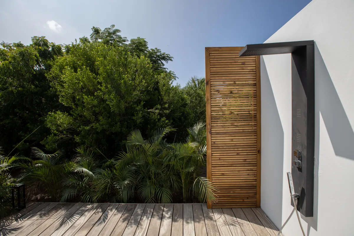 Villa Nuit D'Etoiles: Outdoor shower on a wooden deck with privacy screen and lush tropical greenery