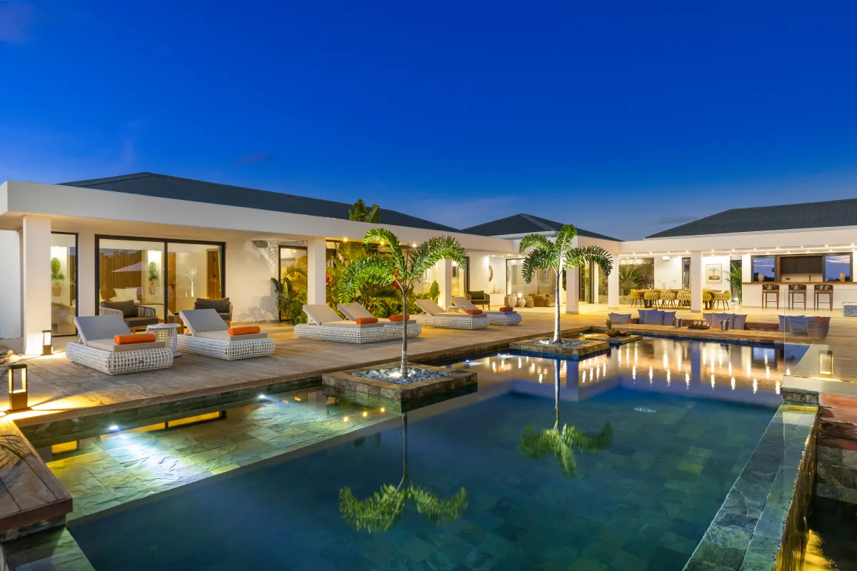 Villa Nuit Jade: Swimming pool with palm tree planters and sun loungers on a terrace at dusk