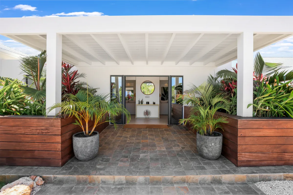 Villa Nuit Jade: Covered villa entrance with potted palm plants leading to an open doorway