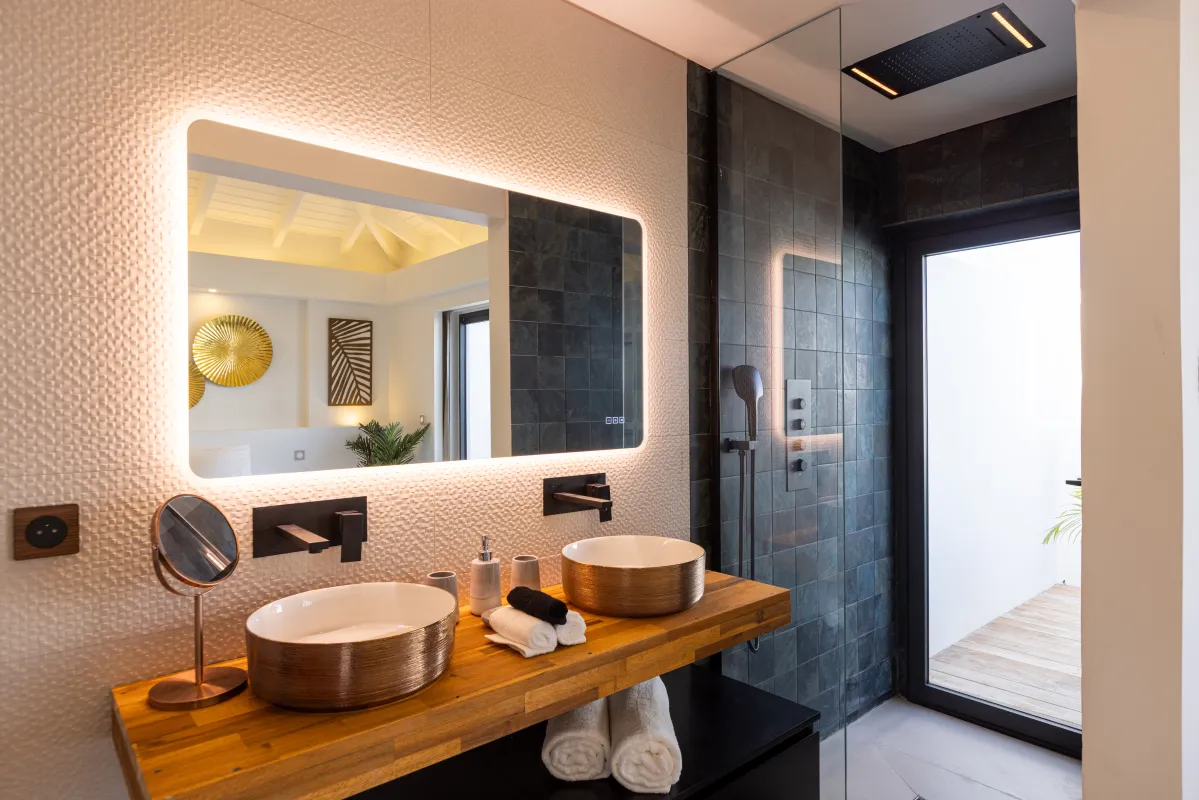 Villa Nuit Jade: Modern bathroom featuring an illuminated vanity mirror, double vessel sinks, and walk-in shower