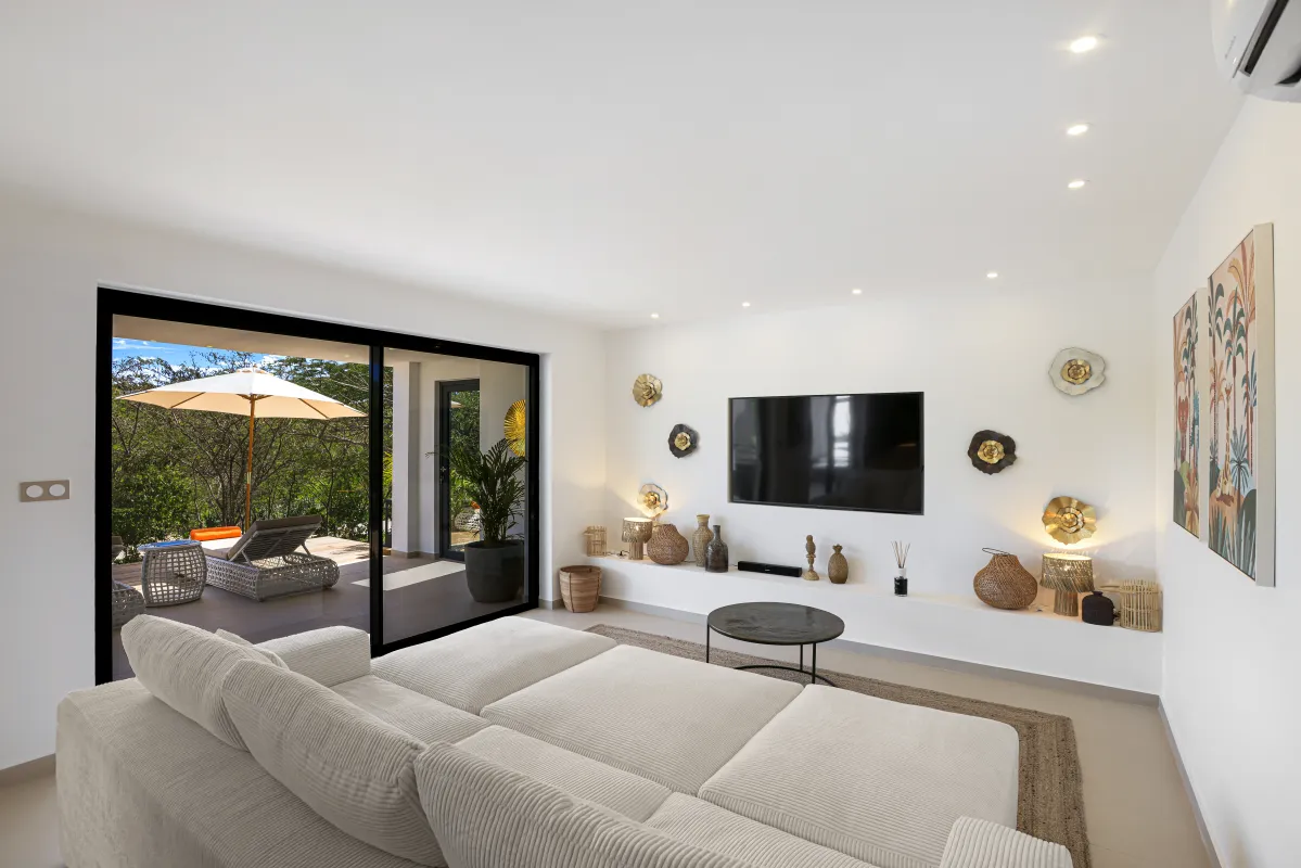 Villa Nuit Jade: Modern living room with a large sectional sofa and sliding doors opening to a terrace