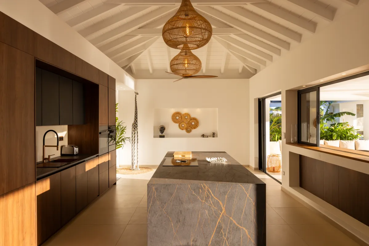 Villa Nuit Jade: Modern kitchen with a large stone island, dark wood cabinets, and woven pendant lights