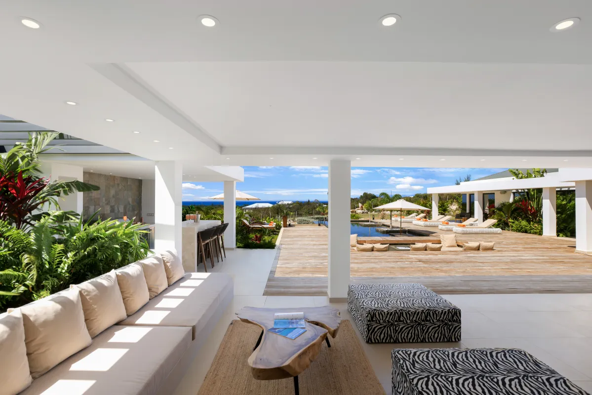 Villa Nuit Jade: Covered terrace lounge opening onto a wooden deck with a swimming pool and ocean view
