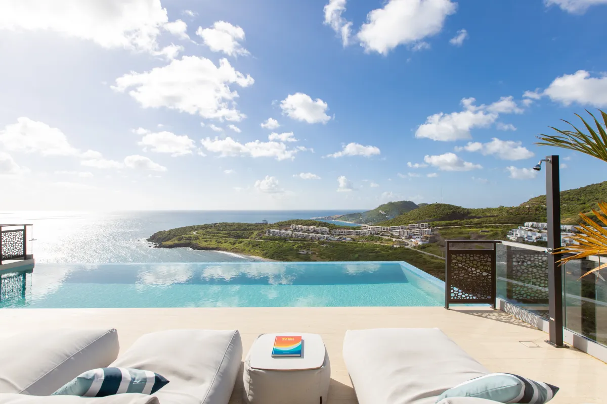 Villa Numa: Infinity edge pool and cushioned lounge chairs overlooking the ocean and coastline