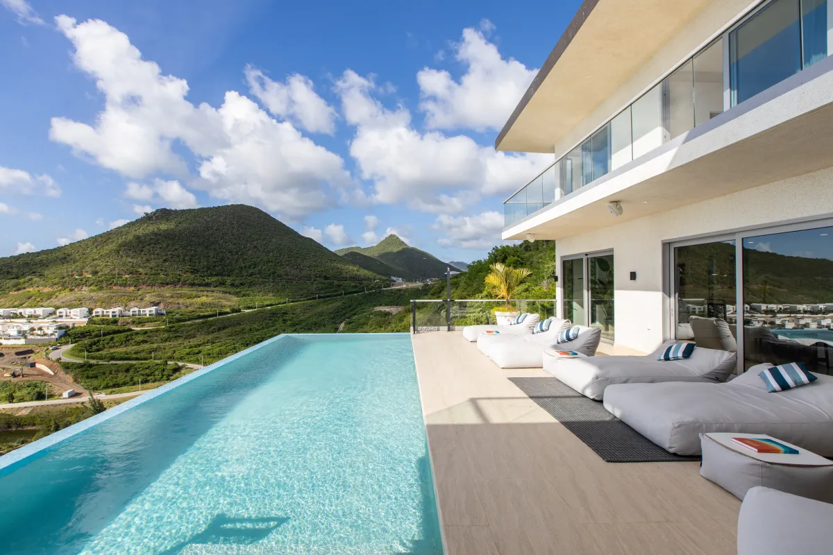Villa Numa: Infinity pool and sunny terrace with cushioned daybeds overlooking green hills