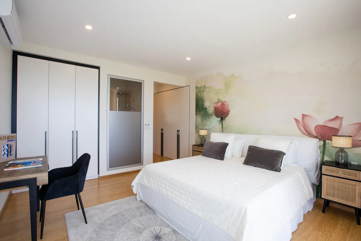 Villa Numa: Bedroom with a white bed, floral wall mural, small desk, and built-in wardrobes