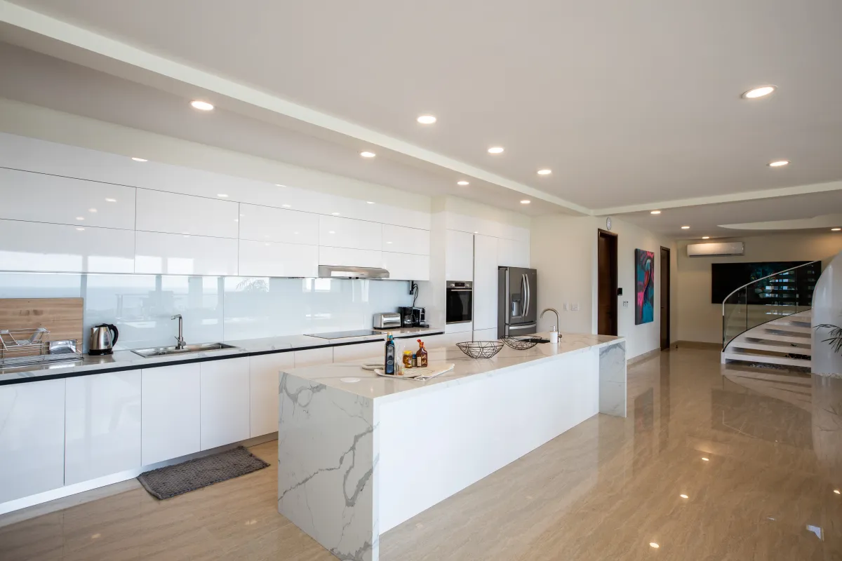 Villa Numa: Modern open kitchen with glossy white cabinetry and large marble island