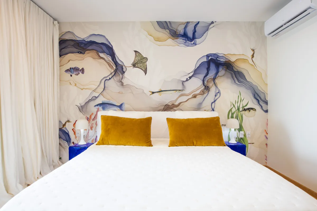 Villa Numa: Bedroom with a king bed, yellow accent pillows, and an underwater-themed wallpaper mural