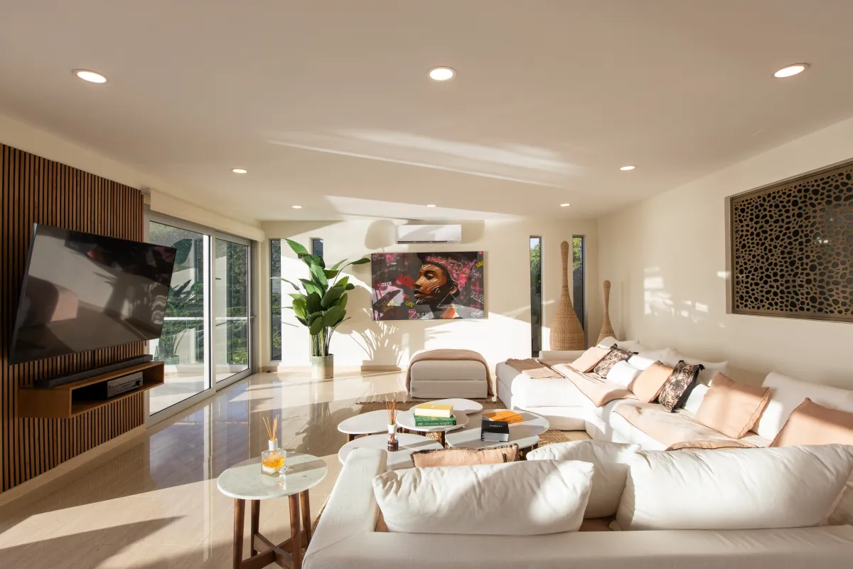 Villa Numa: Modern living room with a large white sectional sofa and wall-mounted television