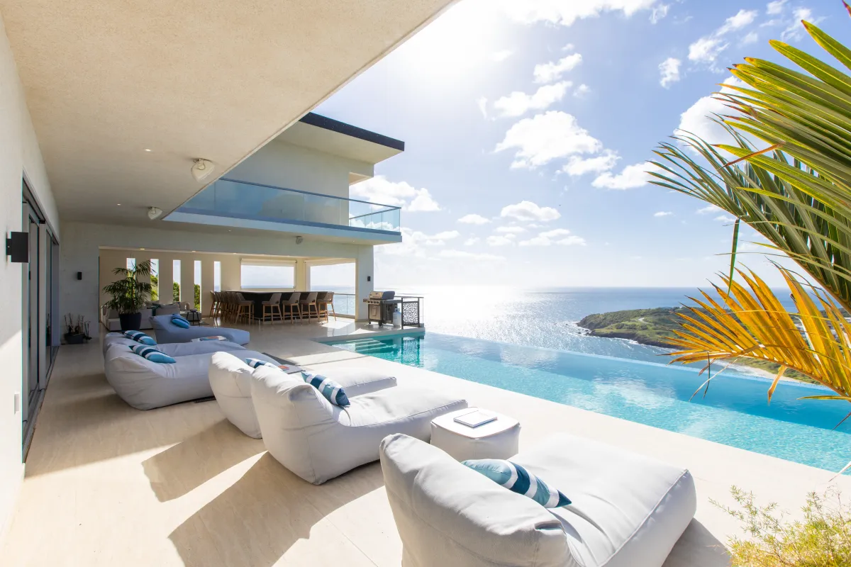 Villa Numa: Infinity pool and cushioned lounge chairs on a terrace overlooking the sea