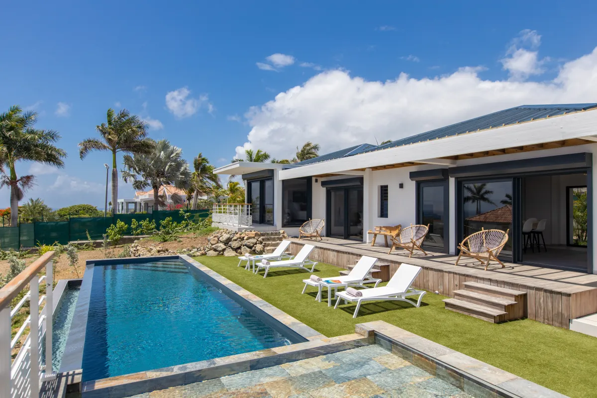 Villa Ocean's One: Swimming pool and lounge chairs on artificial lawn beside a modern single-story villa