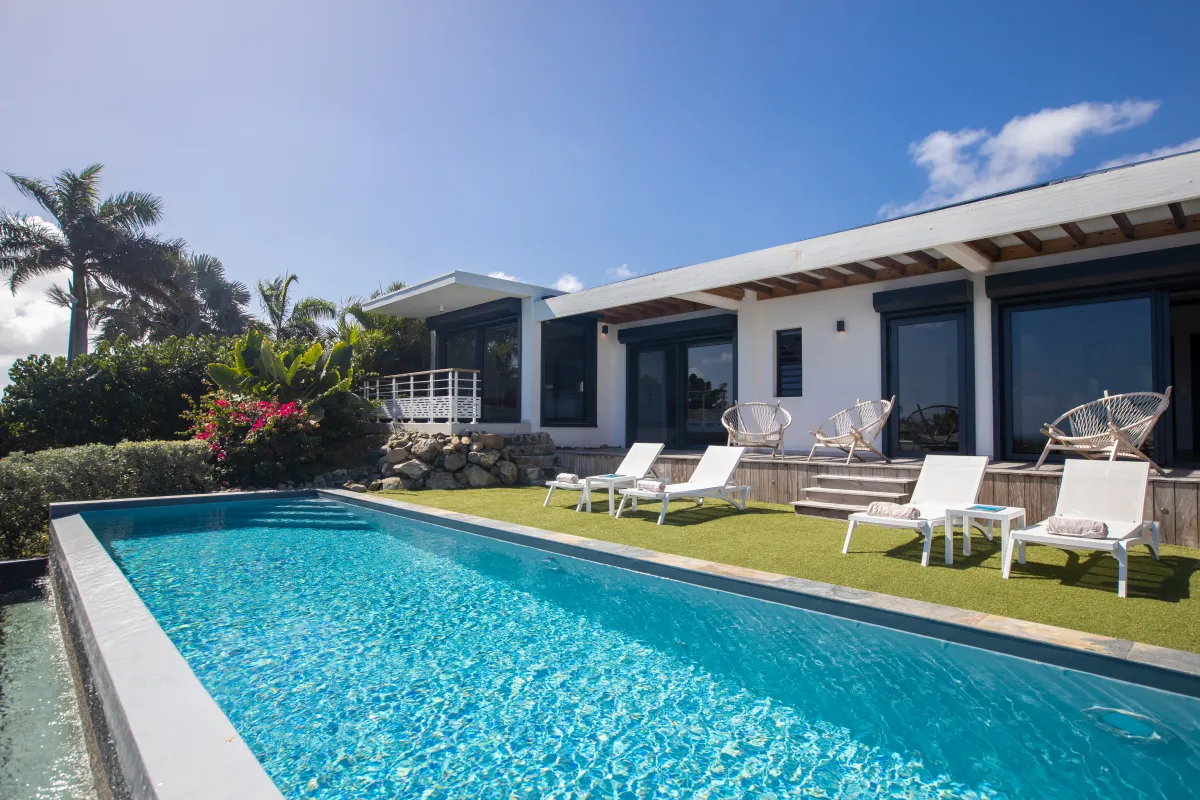 Villa Ocean's One: Swimming pool and sun loungers on artificial lawn beside a modern single-story villa