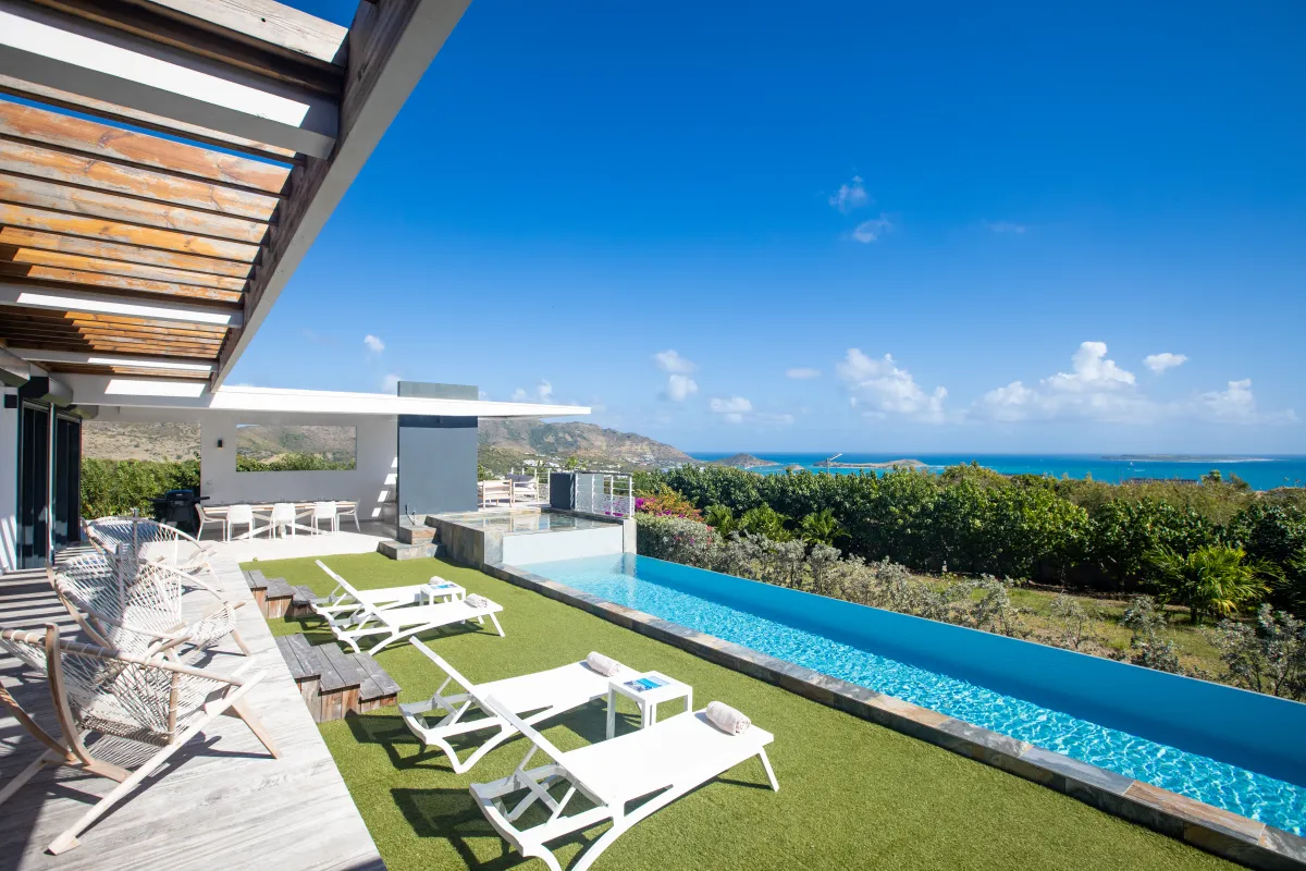 Villa Ocean's One: Terrace with a lap pool, sun loungers on turf, and an ocean view