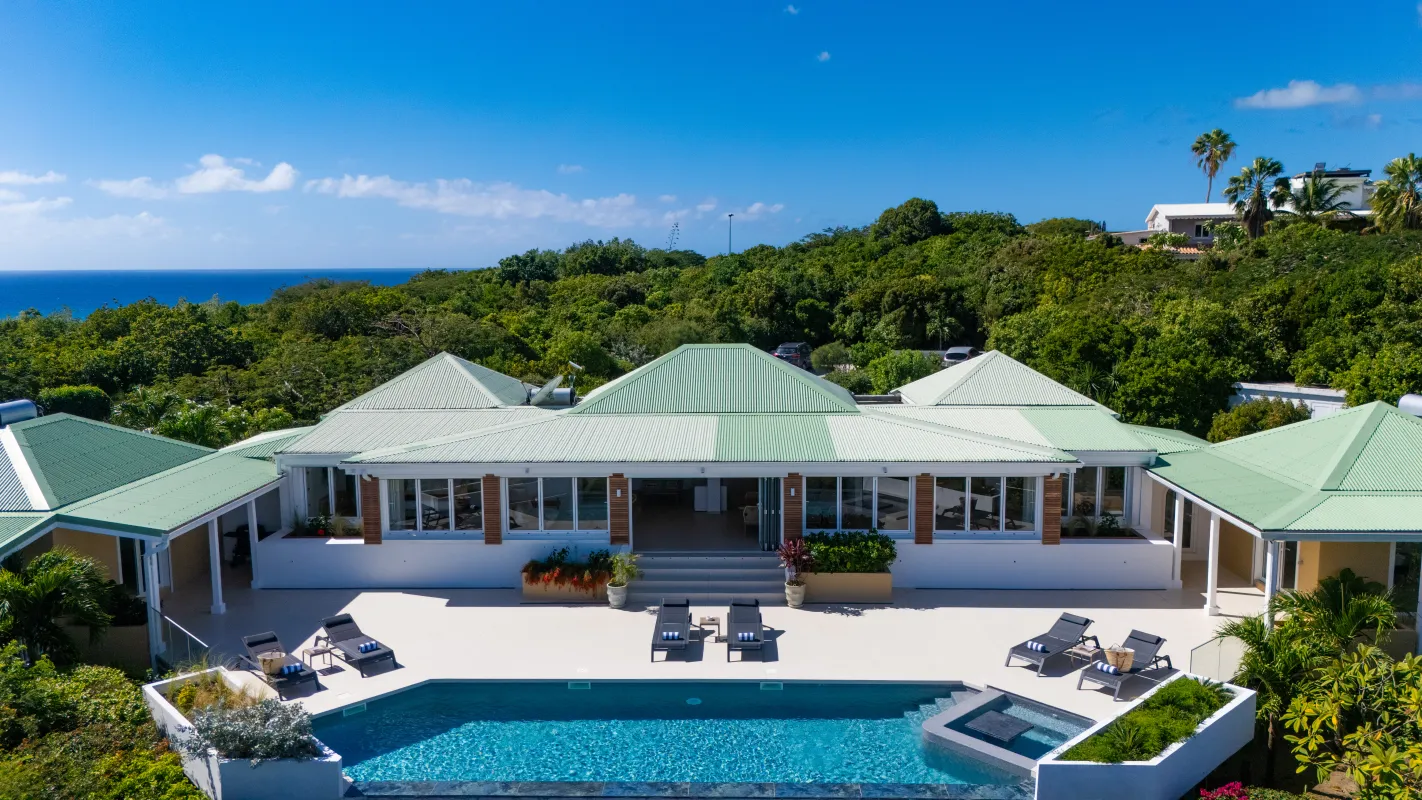 Villa Osun: Villa with green roofs, swimming pool, sun loungers, and ocean view in the background